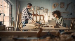 Two Carpenters Working Together in a Woodwork Workshop. Multicul